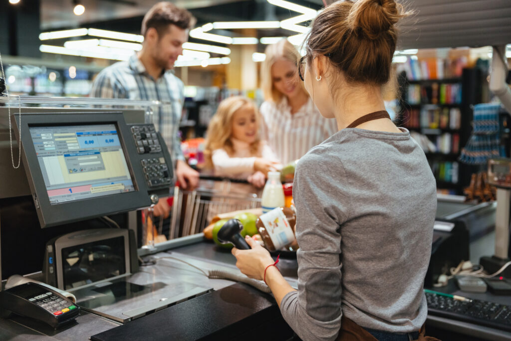 Beautiful family standing at the cash counter software de gestão para retalho
